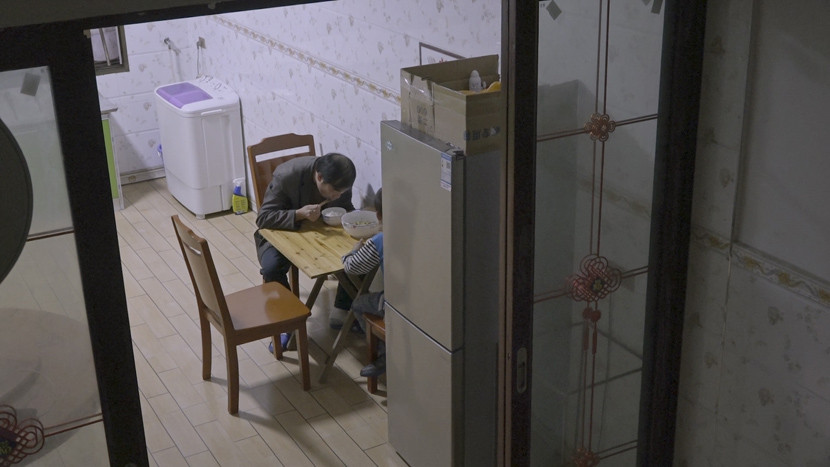 2020年9月，龙代兵和小儿子在重庆农村的家中吃饭。为了照顾家人，他放弃了上海的工作。图源：第六声_副本.jpg